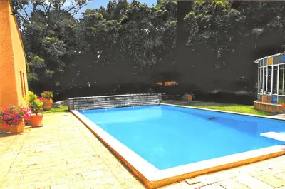 a large blue swimming pool sitting next to a house at Appartement lumineux à Lançon-Provence, piscine partagée in Lançon-Provence