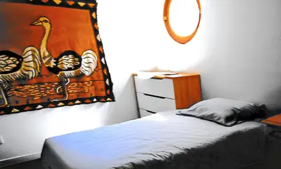 a bedroom with a bed and a painting of two birds at Appartement lumineux à Lançon-Provence, piscine partagée in Lançon-Provence