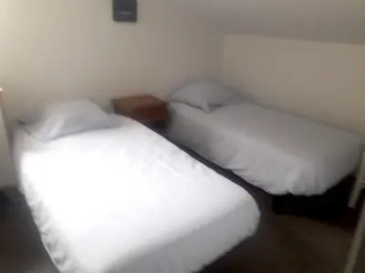 two beds in a small room with white sheets and pillows at Appartement lumineux à Lançon-Provence, piscine partagée in Lançon-Provence