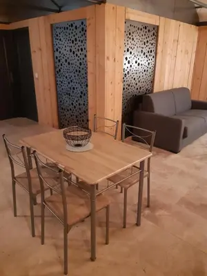 a wooden table with two chairs and a couch at DANSAVAN Chambres d Hôtes Gite in Oppède