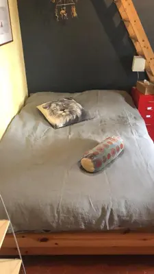a wooden bed with a pillow on top of it at Les Volets Bleus Provence in Salon-de-Provence