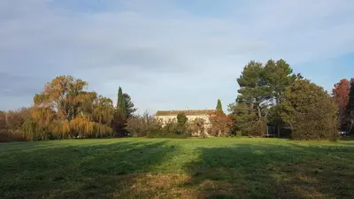 a large grass field with a house in the background at Mas de Férigoulet -