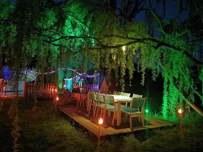 a table and chairs under a tree with lights at Mas de Férigoulet -