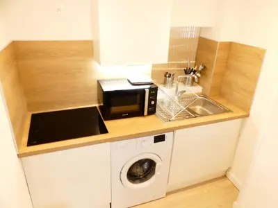 a kitchen with a microwave and a washing machine at LE BEDARRIDE in Aix-en-Provence