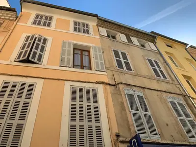 a tall building with windows and shutters on it at LE BEDARRIDE in Aix-en-Provence