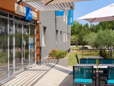 a restaurant with tables and chairs and a bar at ibis budget Pertuis Portes du Luberon in Pertuis
