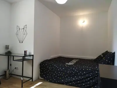 a small bedroom with a bed and a table at Maison dans quartier calme in LʼIsle-sur-la-Sorgue