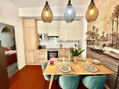 a kitchen with a wooden table and blue chairs at Dar Saad Appartement terrasse climatisation centre d Aix in Aix-en-Provence