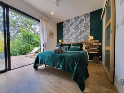 a bedroom with a large bed and a sliding glass door at Le Phoenix de Sainte Victoire in Saint-Marc-Jaumegarde