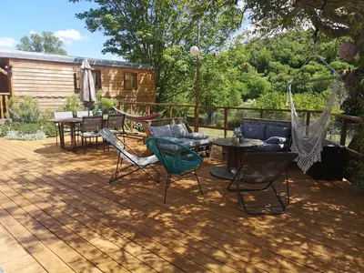 a patio with a hammock and a table and chairs at Roulotte la clé du Luberon in Buoux