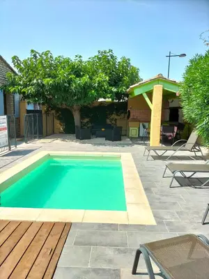 a swimming pool in a yard with a table and chairs at Maison Provençale Spa Sauna Piscine in Mollégès