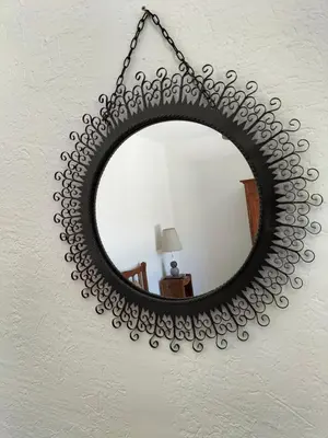 a large circular mirror hanging on a wall at Maison Provençale Spa Sauna Piscine in Mollégès
