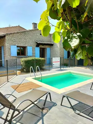 a swimming pool with two chairs next to a house at Maison Provençale Spa Sauna Piscine in Mollégès