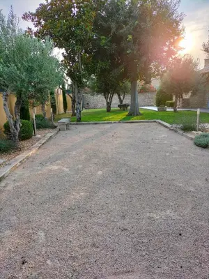 a gravel driveway with trees in a park at Maison Provençale Spa Sauna Piscine in Mollégès