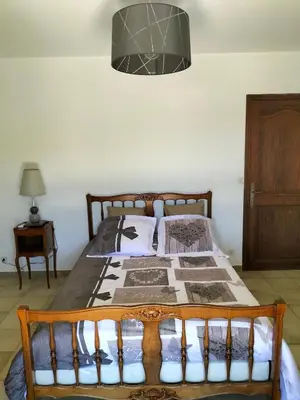 a bedroom with a bed with a wooden frame at Maison Provençale Spa Sauna Piscine in Mollégès