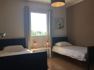 a bedroom with two beds and a window at Pleasant part of house with pool to share in Vaucluse, 4/6 people in Puget