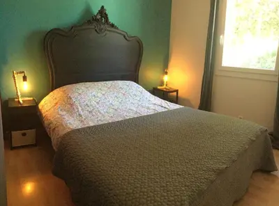 a bedroom with a large bed with two lamps at Pleasant part of house with pool to share in Vaucluse, 4/6 people in Puget