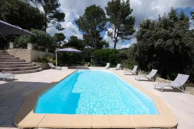 a swimming pool with chaise lounge chairs and a swimming pool at Pleasant part of house with pool to share in Vaucluse, 4/6 people in Puget