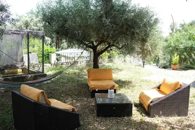 two chairs and a hammock in a yard with a tree at Pleasant part of house with pool to share in Vaucluse, 4/6 people in Puget