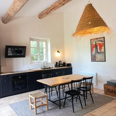 a kitchen with a table and chairs in a room at Le Cottage du Chat Blanc in Saint-Didier
