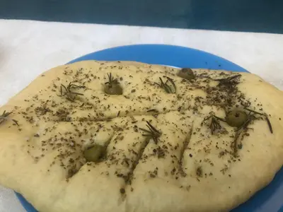 a pizza with insects on it on a blue plate at Maison Lou Roucas in Cabrières-dʼAigues