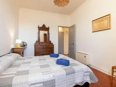 a bedroom with a large bed with blue pillows on it at Holiday Home Mas de la Gourmette by Interhome in Châteaurenard