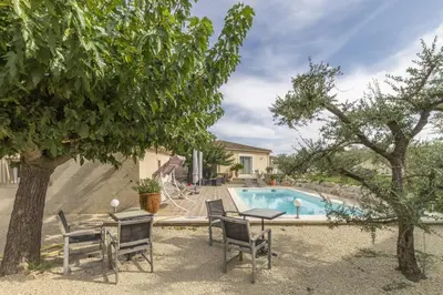 a backyard with a table and chairs and a swimming pool at Villa Mireillo in Noves