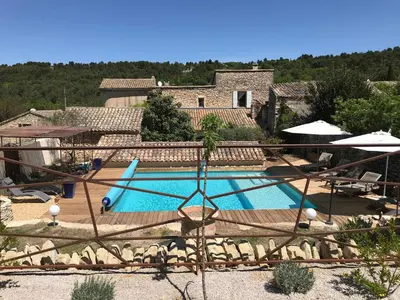 a swimming pool in front of a house at Bastide La Destinée in Ménerbes
