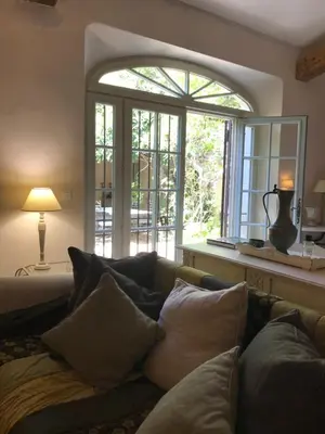 a living room with a couch and a large window at Bastide La Destinée in Ménerbes