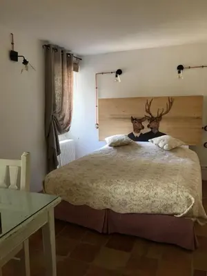 a bedroom with a large bed with a wooden headboard at Bastide La Destinée in Ménerbes
