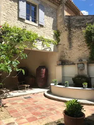 a house with a courtyard with a fountain in front of it at Bastide La Destinée in Ménerbes