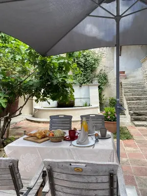 a table with an umbrella on a patio at Bastide La Destinée in Ménerbes