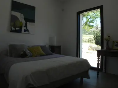 a bedroom with a bed and a large window at Là Mésange de Venasque in Venasque