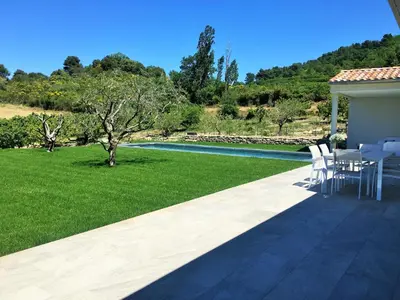 a patio with a table and chairs and a pool at Là Mésange de Venasque in Venasque