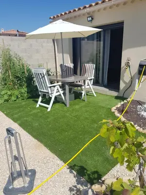 a backyard with a table and chairs and an umbrella at Chambre chez Ikrame in Malemort-du-Comtat