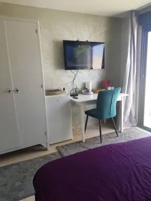 a bedroom with a desk and a chair and a tv at Chambre chez Ikrame in Malemort-du-Comtat