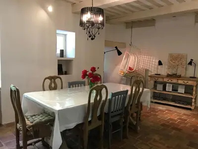 a dining room with a white table and chairs at Le mas jasmins in Ménerbes