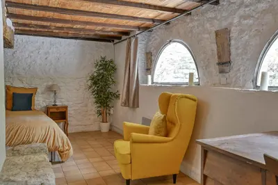 a bedroom with a bed and a yellow chair at Santonne in Apt
