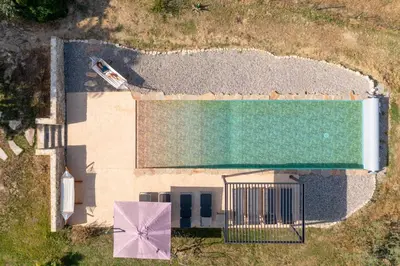 an overhead view of a swimming pool with a pink umbrella at Mas Côté Cour in Maubec