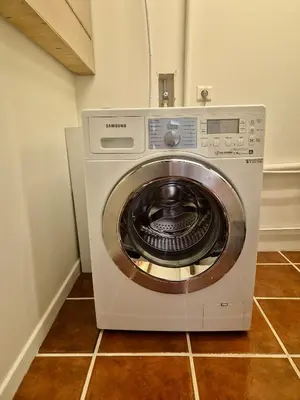 a washing machine in a room with a tile floor at Mas Côté Cour in Maubec