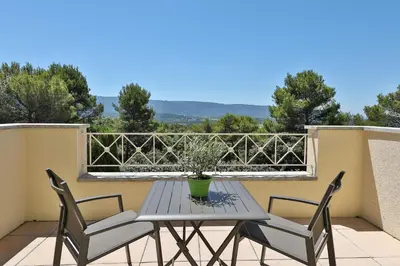 a table and two chairs on a balcony at Quintessence Provence in Goult