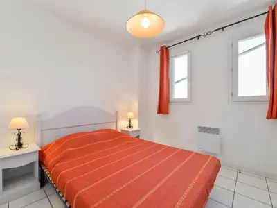 a white bedroom with a bed and two windows at Residence Sun Hols Les Rives du Lac in Saint-Saturnin-lès-Avignon