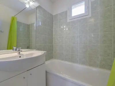 a bathroom with a sink and a bath tub at Residence Sun Hols Les Rives du Lac in Saint-Saturnin-lès-Avignon