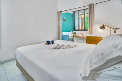 a bedroom with a white bed with a table and a window at Les Nids de la Diane - Appart'Conforts in Pertuis