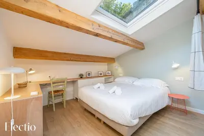 a bedroom with a large white bed and a desk at Les Nids de la Diane - Appart'Conforts in Pertuis