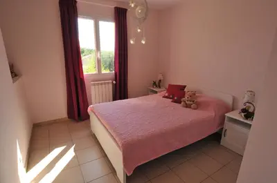 a bedroom with a pink bed with a teddy bear on it at Gîte de Catherine in Saint-Didier