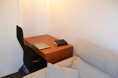 a desk with a laptop on it next to a bed at Floridianes by HRI in Aix-en-Provence