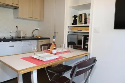 a kitchen with a table with glasses and a bottle of wine at Floridianes by HRI in Aix-en-Provence