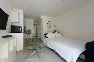 a bedroom with a bed with a glass table in it at Provençal Studio Netflix Appart-hotel-Provence in La Fare-les-Oliviers