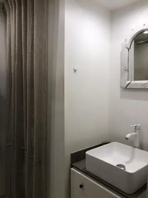 a white bathroom with a sink and a mirror at La petite maison in Lourmarin